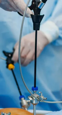 A surgeon handling a laparoscopic instrument during a minimally invasive procedure.